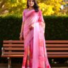 Lady in baby pink Kota cotton saree featuring vibrant floral patterns and check texture.