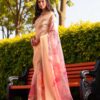 Woman wearing cream beige Kota cotton saree with soft prints and fine check weave.