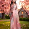 Woman wearing peach pink Kota cotton saree with subtle check design and plain pastel border.